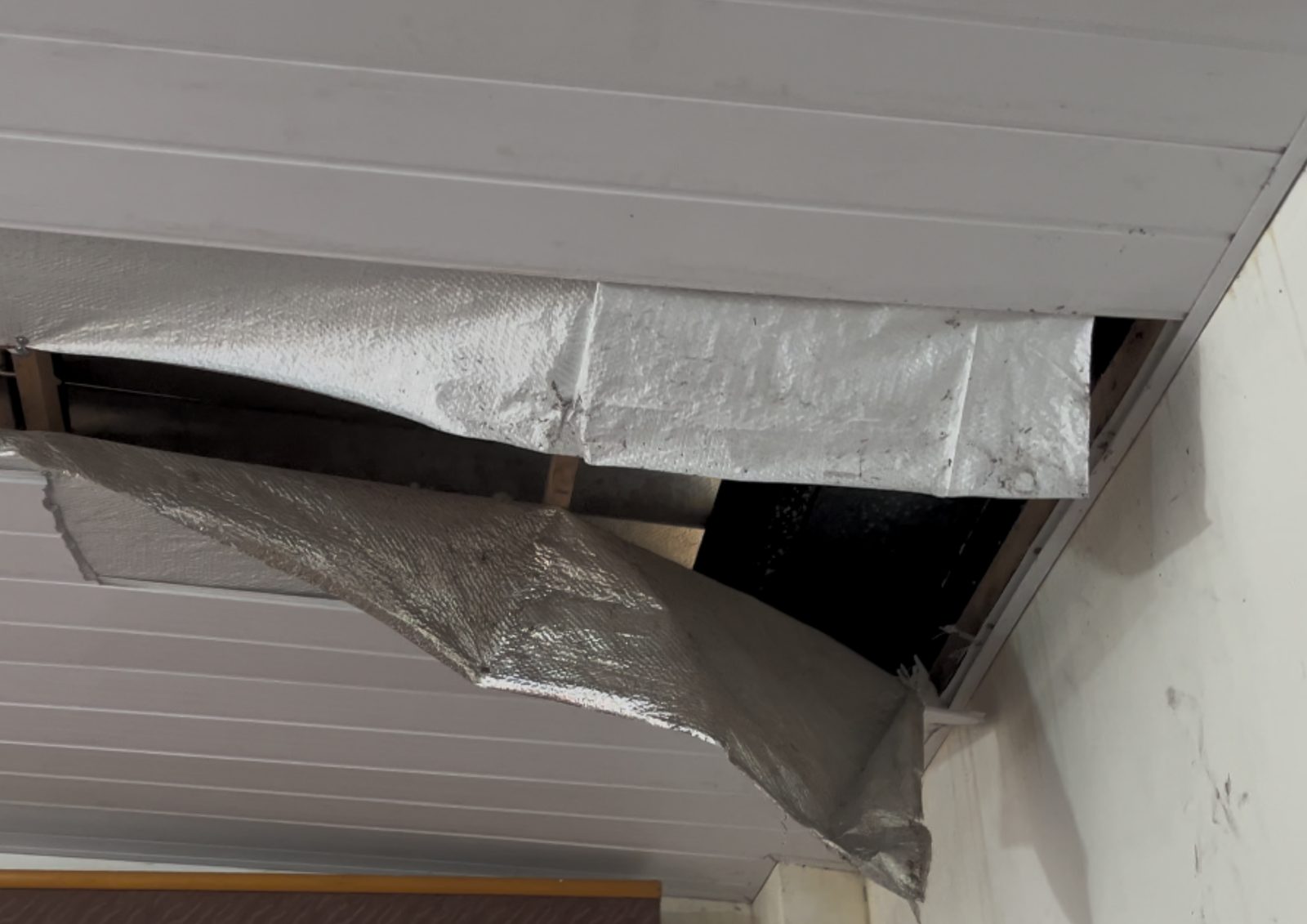 Teto com placas soltas e isolamento exposto